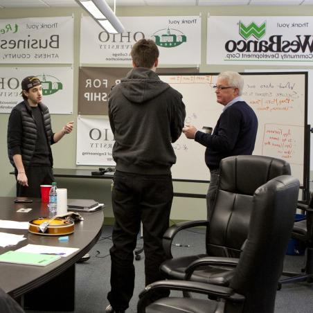 TechGROWTH Ohio staff talk in front of a whiteboard